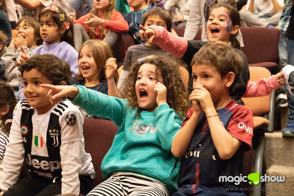 Marcell realizando magia frente a niños en un evento escolar